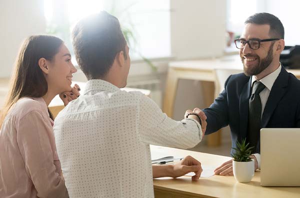 couple shaking banker's hand